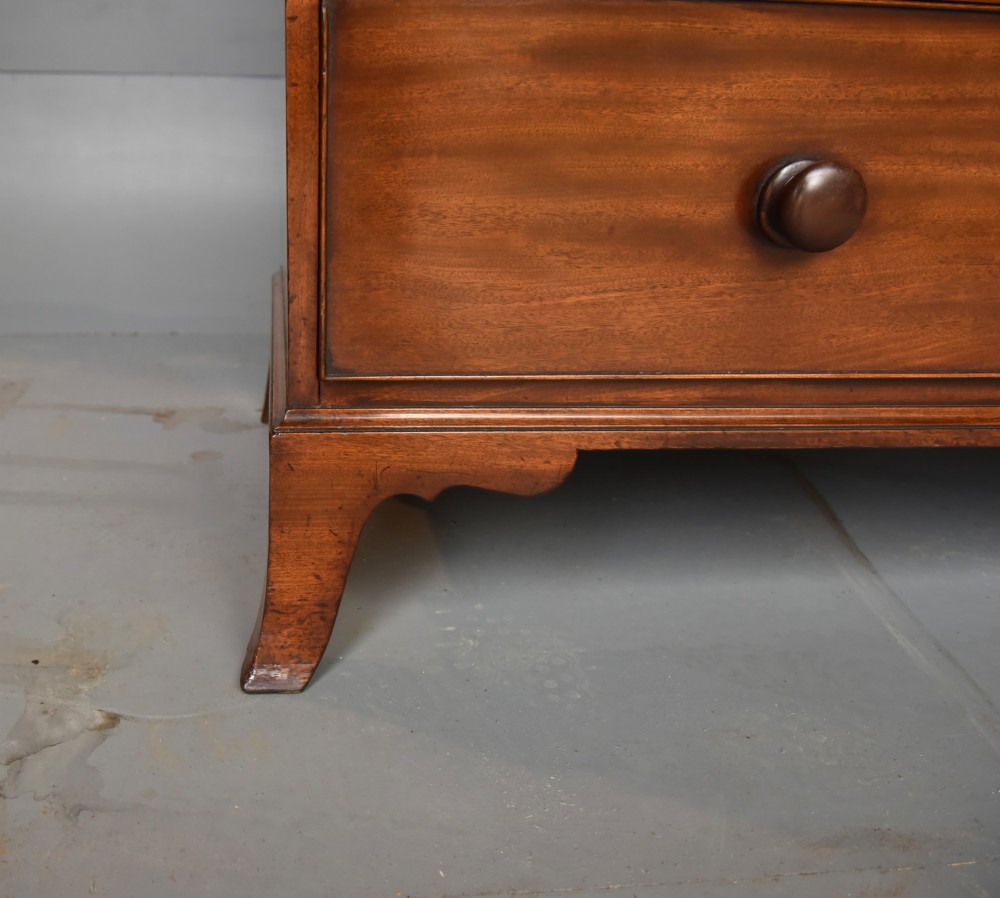 A Georgian mahogany gentlemans wardrobe featuring a two-door upper section with ebony line inlay over a base of two short and two long drawers on bracket feet. View VIII