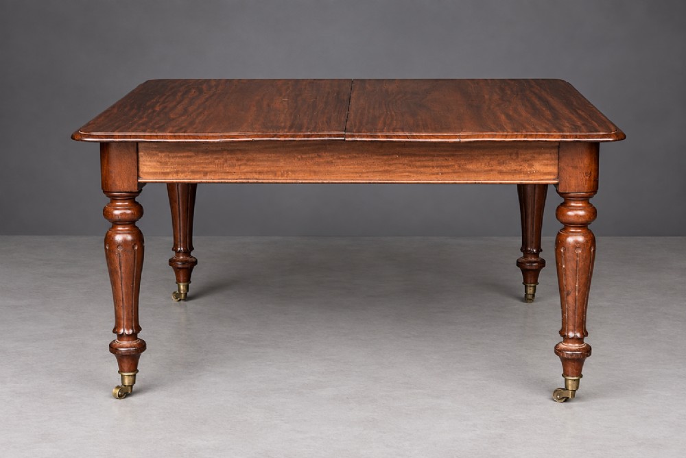 A Victorian mahogany extending dining table with turned legs resting on brass castors and an expanding rectangular top. View V