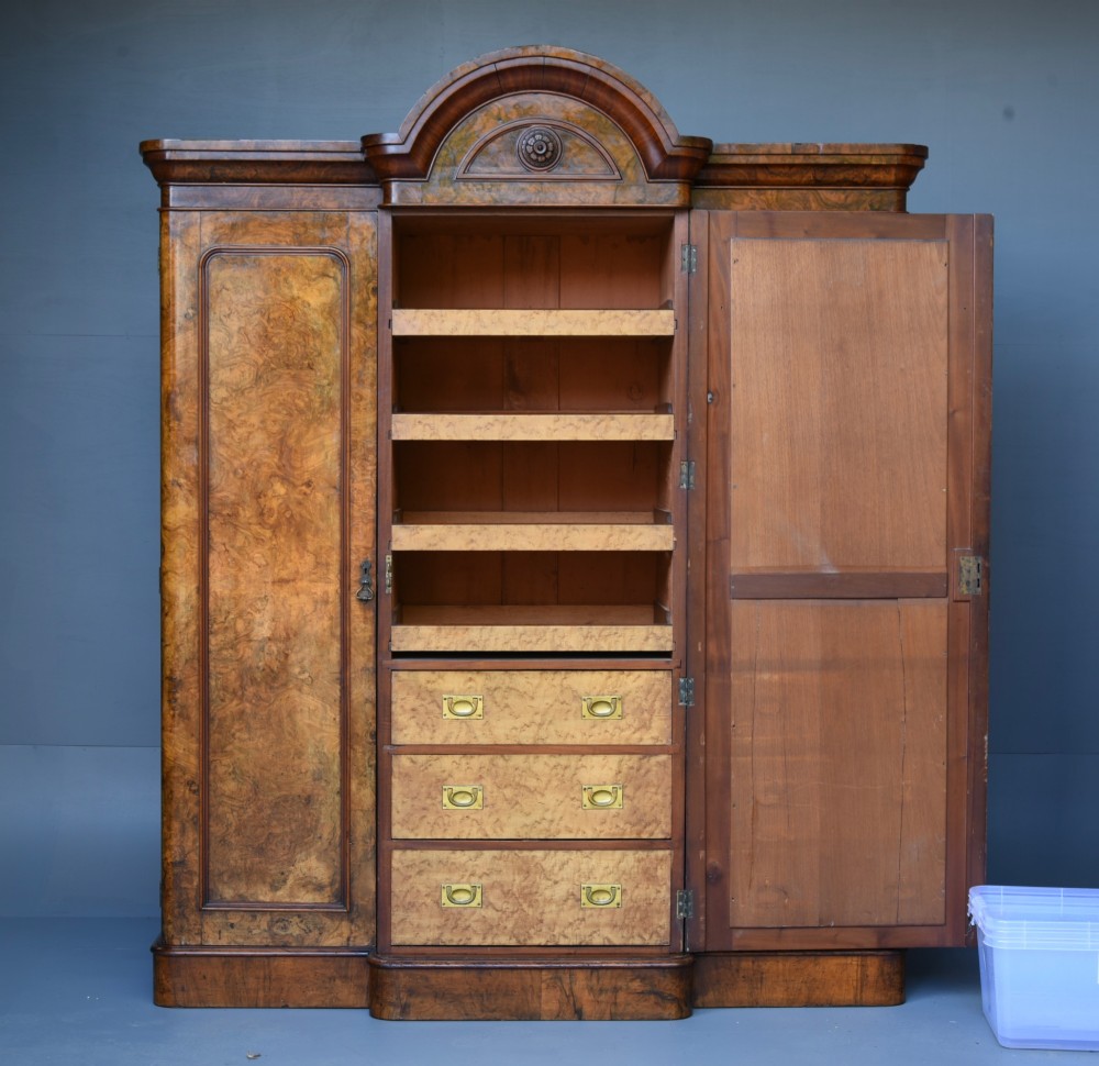 A Victorian burr walnut triple wardrobe featuring an arched central mirrored door flanked by two panelled timber doors with carved mouldings. View III