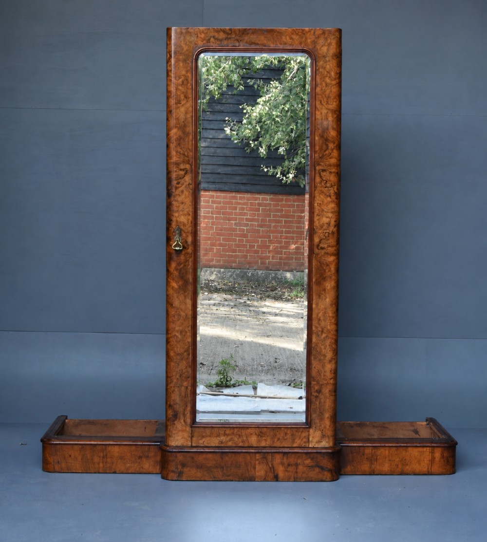 A Victorian burr walnut triple wardrobe featuring an arched central mirrored door flanked by two panelled timber doors with carved mouldings. View VI