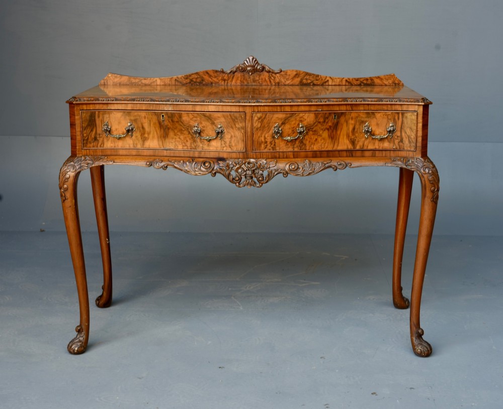 A Queen Anne style burr walnut side table featuring two drawers with brass handles, carved cabriole legs, and a raised gallery top. View II