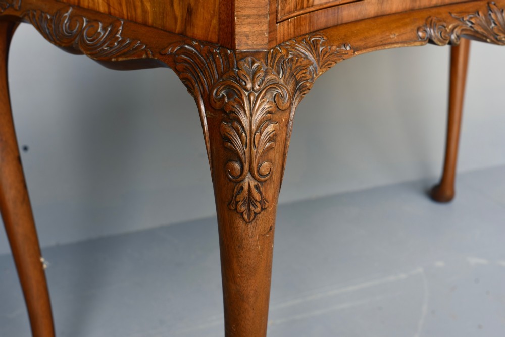 A Queen Anne style burr walnut side table featuring two drawers with brass handles, carved cabriole legs, and a raised gallery top. View V