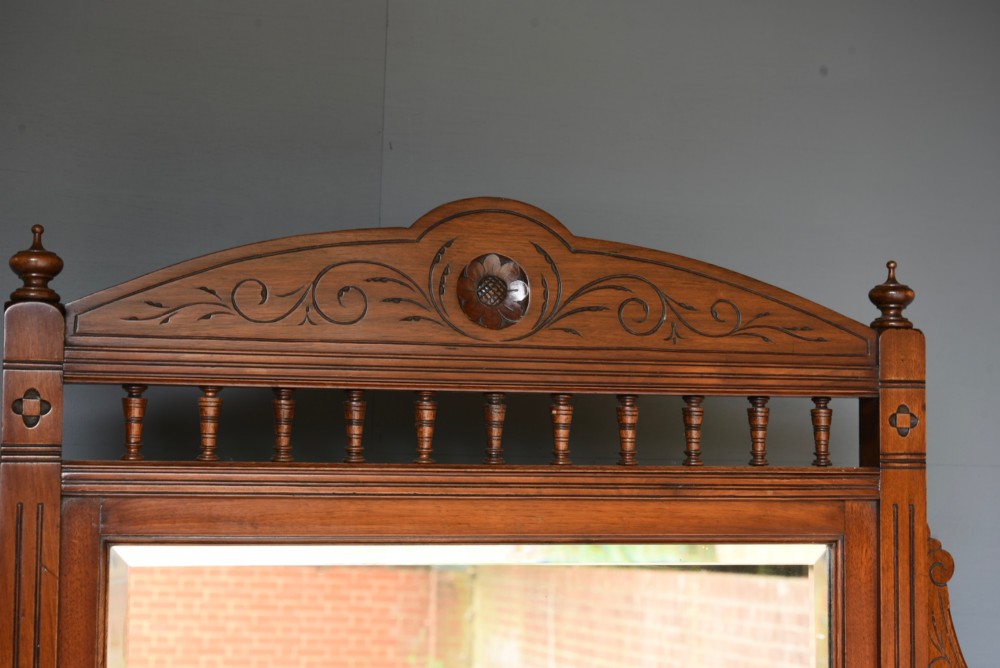 A carved Victorian walnut sideboard with a three-panel mirrored superstructure, spindle galleries, and lower cupboard doors decorated with floral carved panels. View VII