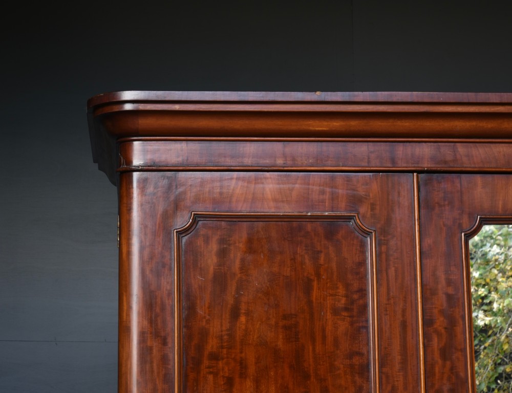 A Victorian mahogany triple wardrobe featuring two outer panelled doors, a central mirrored door, and a moulded cornice top. View V
