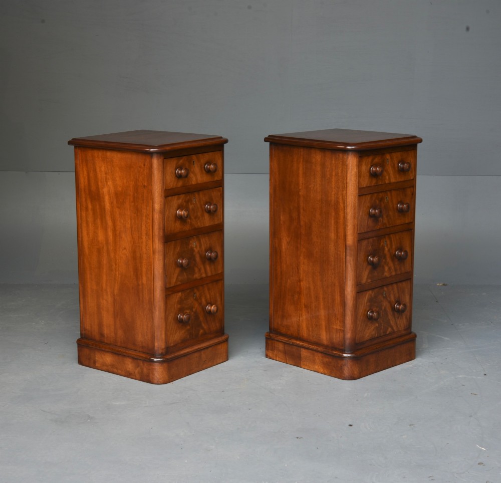 A matching pair of tall Victorian mahogany bedside chests featuring four graduated drawers with turned wooden handles and a plinth base. View II