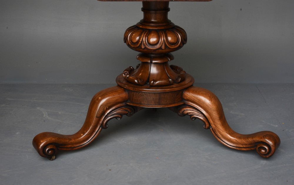 A nineteenth-century circular mahogany tilt-top table with radial flame mahogany veneering set on a carved tripod base with scroll feet. View VI