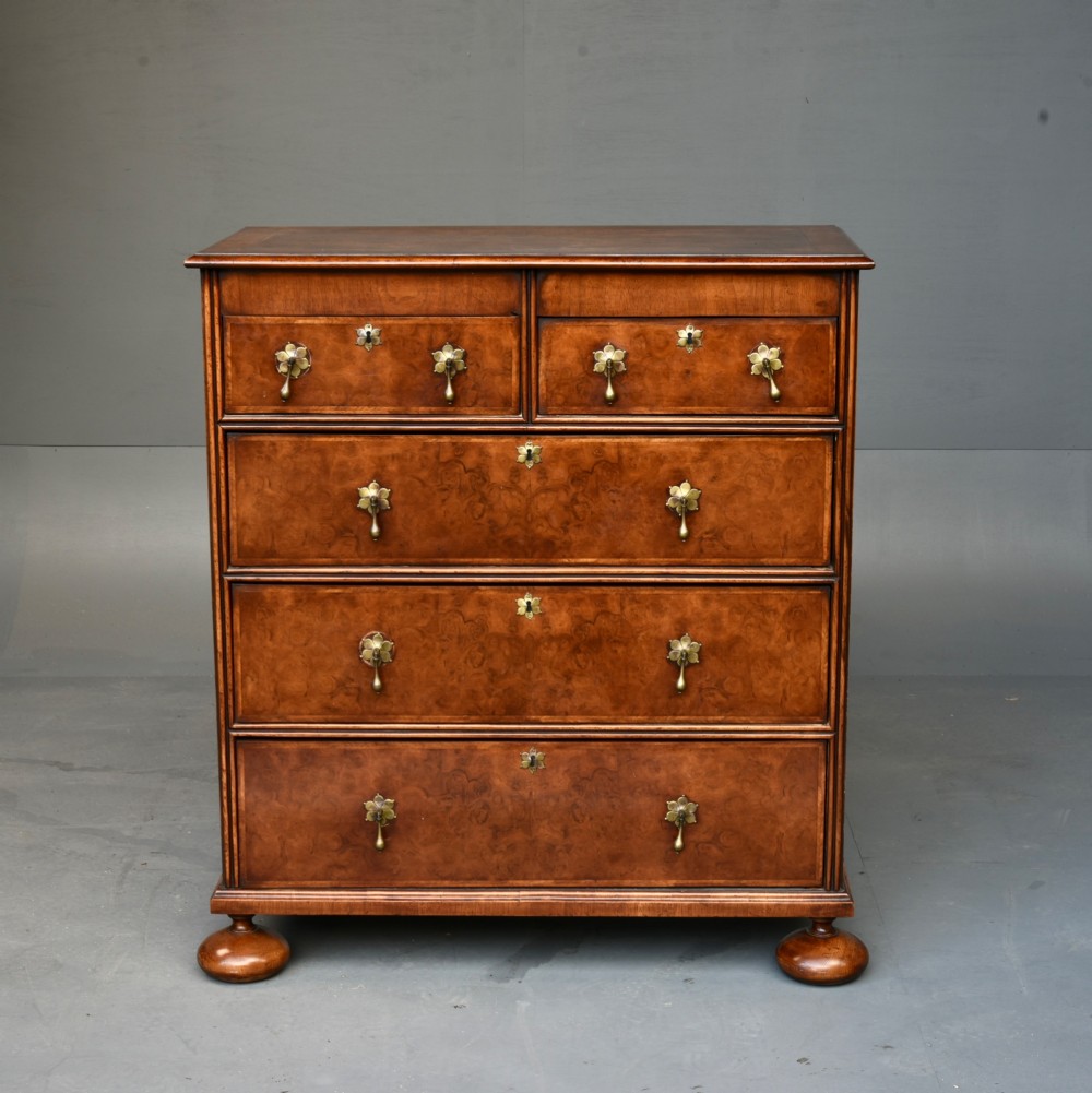 A 19th-century Queen Anne style walnut chest of drawers featuring a two-over-three drawer configuration with brass drop handles and bun feet. View II