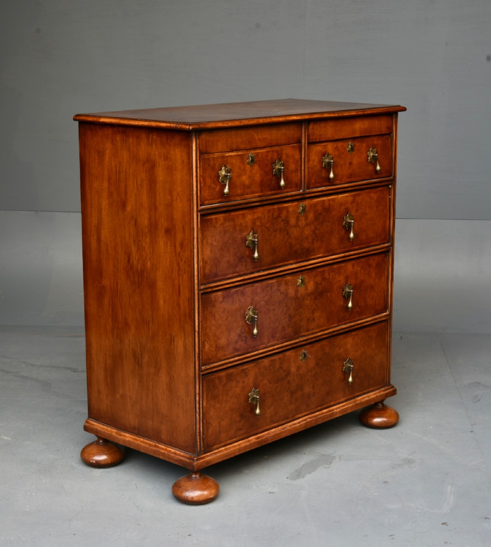 A 19th-century Queen Anne style walnut chest of drawers featuring a two-over-three drawer configuration with brass drop handles and bun feet. View IV