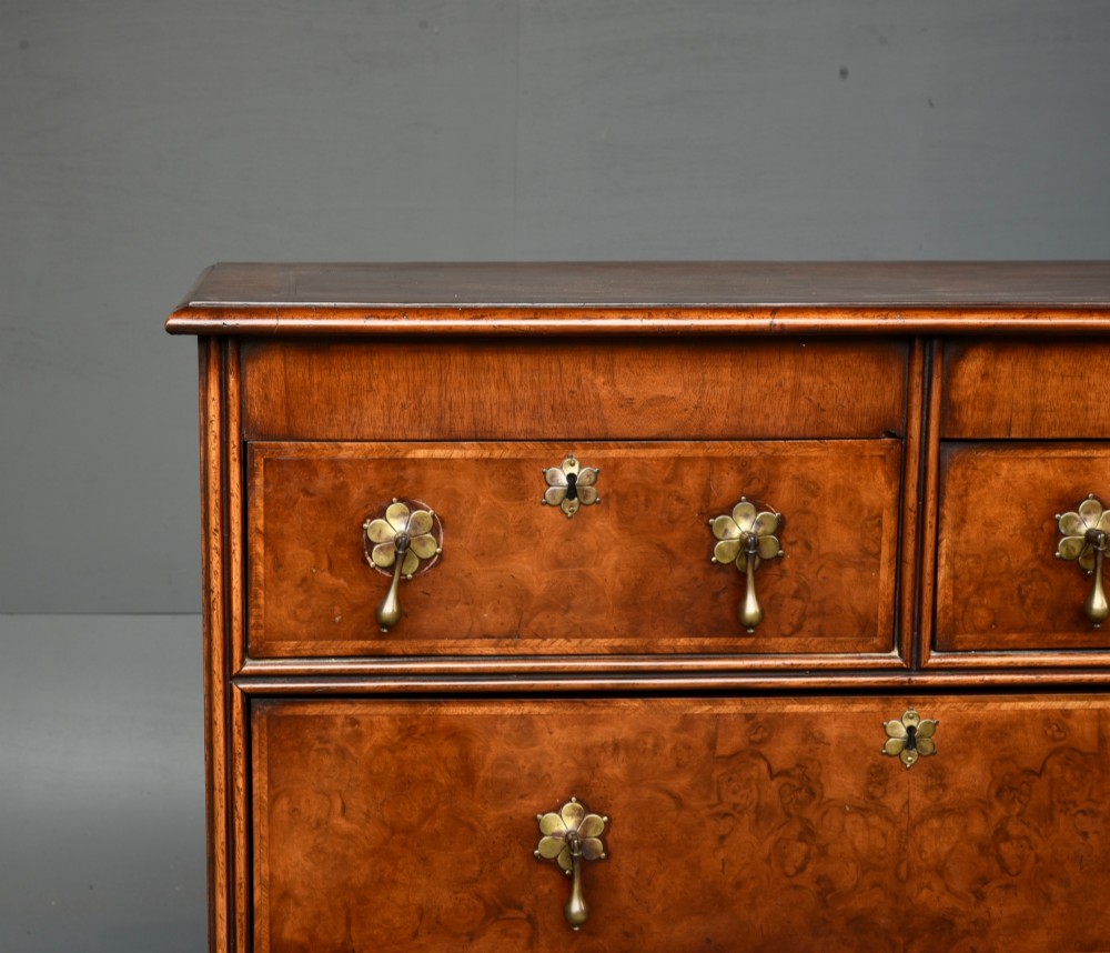 A 19th-century Queen Anne style walnut chest of drawers featuring a two-over-three drawer configuration with brass drop handles and bun feet. View V