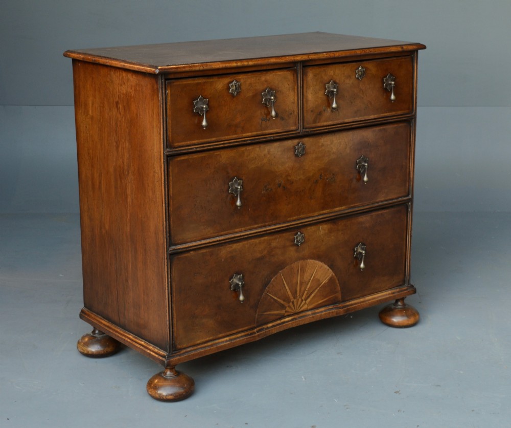 A 19th-century Queen Anne style walnut chest of drawers with two short over two long drawers, brass drop handles, turned bun feet, and a fan-shaped sunburst inlay. View II