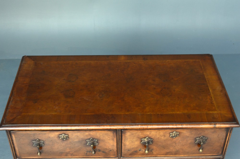 A 19th-century Queen Anne style walnut chest of drawers with two short over two long drawers, brass drop handles, turned bun feet, and a fan-shaped sunburst inlay. View IV