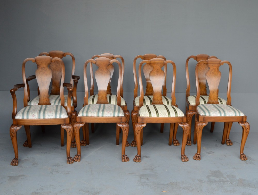 A figured walnut Queen Anne style extending dining table surrounded by eight matching splat-back chairs with carved cabriole legs and upholstered seat cushions. View III