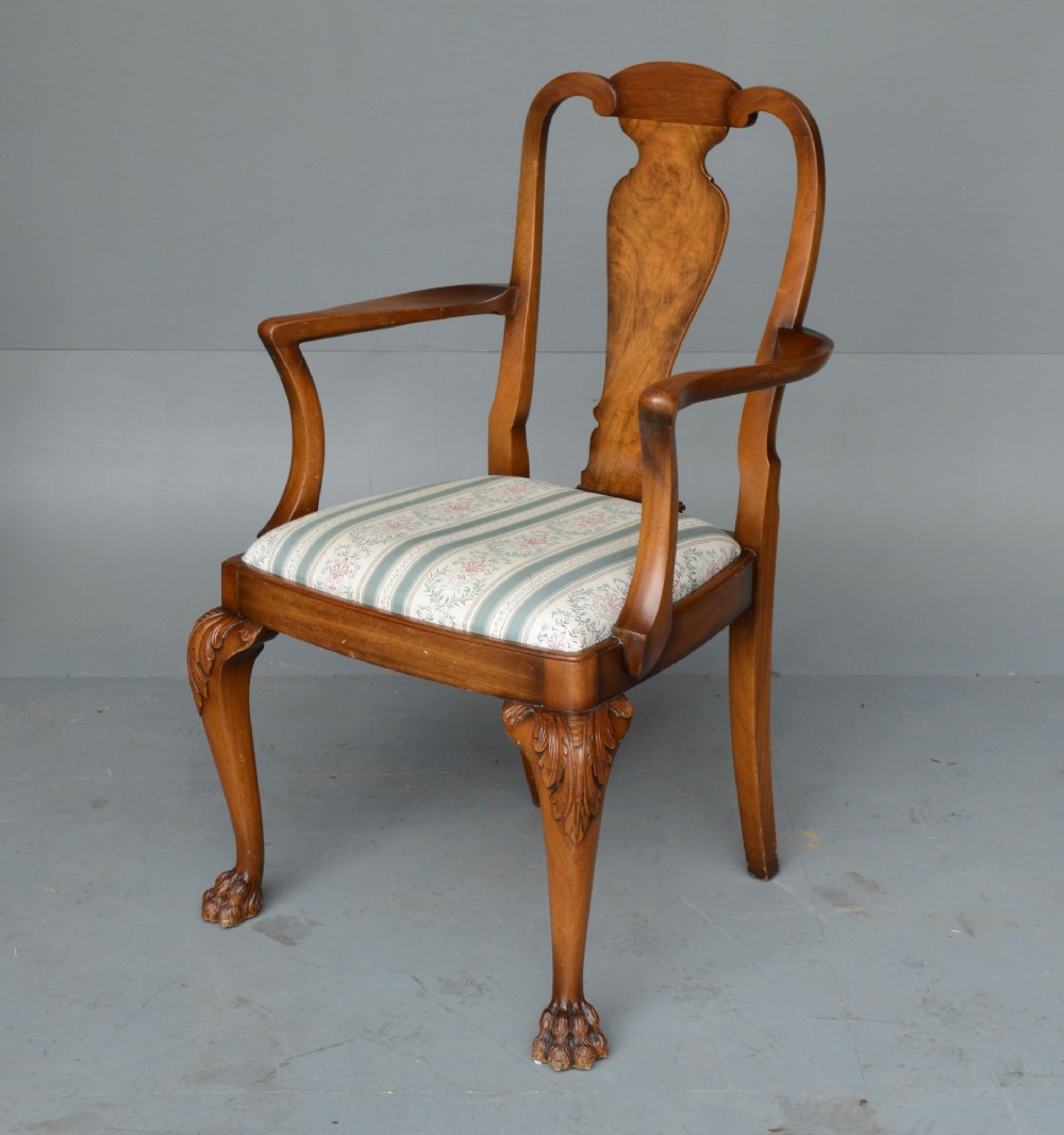 A figured walnut Queen Anne style extending dining table surrounded by eight matching splat-back chairs with carved cabriole legs and upholstered seat cushions. View IV