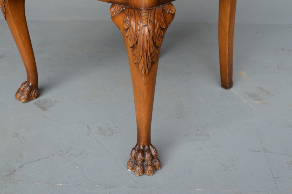 A figured walnut Queen Anne style extending dining table surrounded by eight matching splat-back chairs with carved cabriole legs and upholstered seat cushions. View V
