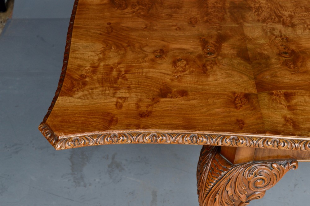 A figured walnut Queen Anne style extending dining table surrounded by eight matching splat-back chairs with carved cabriole legs and upholstered seat cushions. View VII