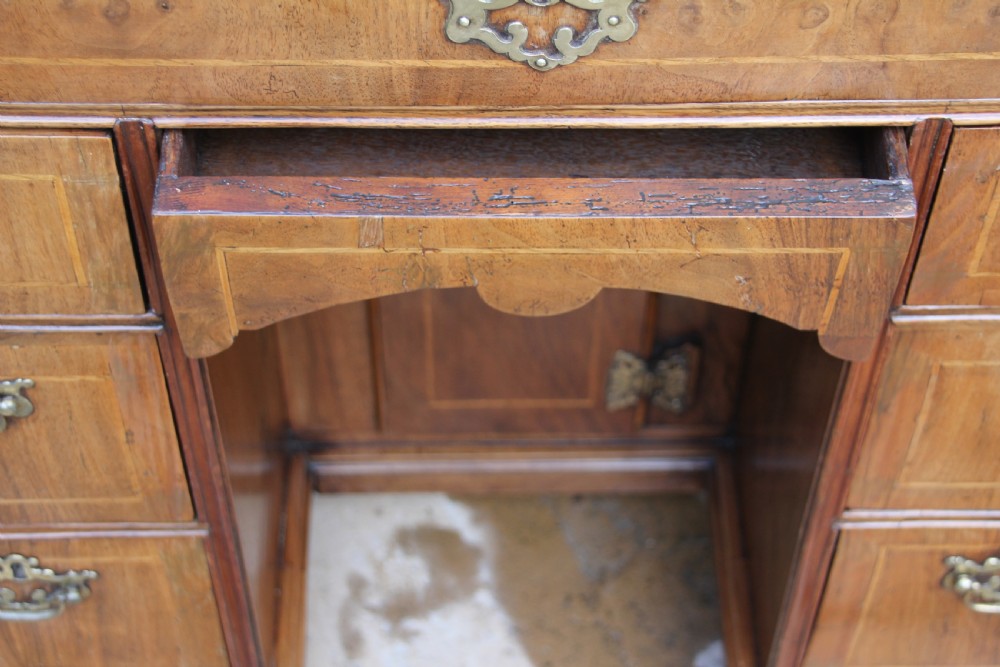 An early 18th century walnut kneehole desk. View VI