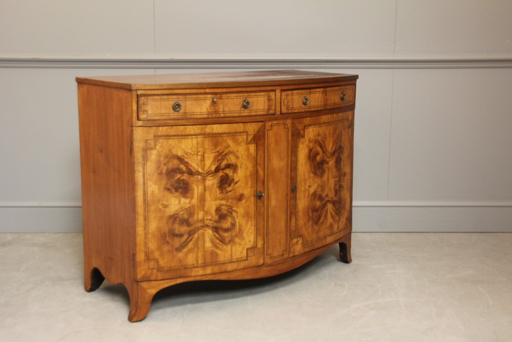A 19th century Bow fronted Satinwood side cabinet View II
