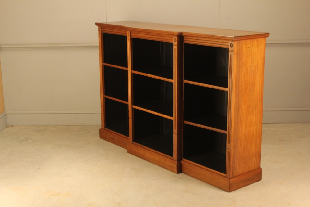 A pair of Edwardian mahogany low open breakfront bookcases featuring three bays and plinth bases. View X