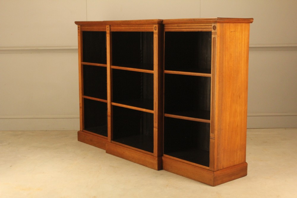 A pair of Edwardian mahogany low open breakfront bookcases featuring three bays and plinth bases. View XI