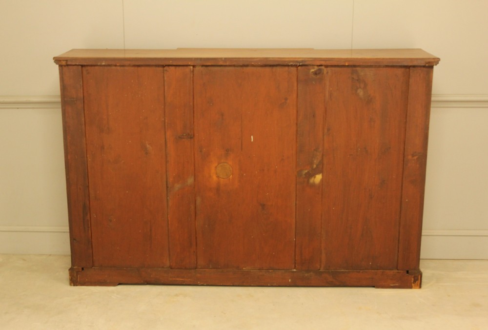 A pair of Edwardian mahogany low open breakfront bookcases featuring three bays and plinth bases. View XVI