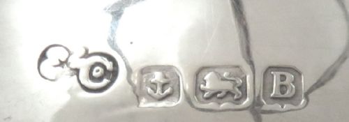 fig 1. A sterling silver golf ball stand featuring three crossed golf club legs supported by a circular silver base holding a white golf ball.