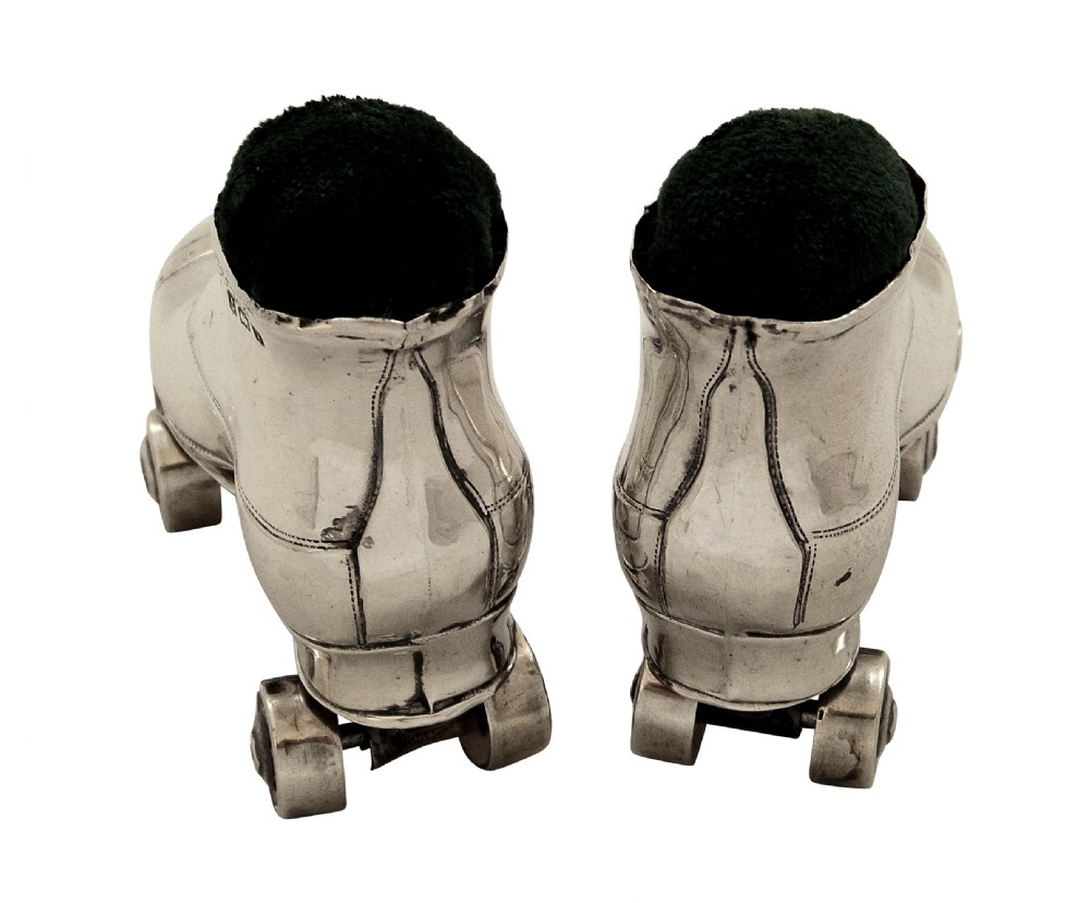 A pair of Edwardian sterling silver roller skate boots fitted with dark green velvet pin cushion tops. View II