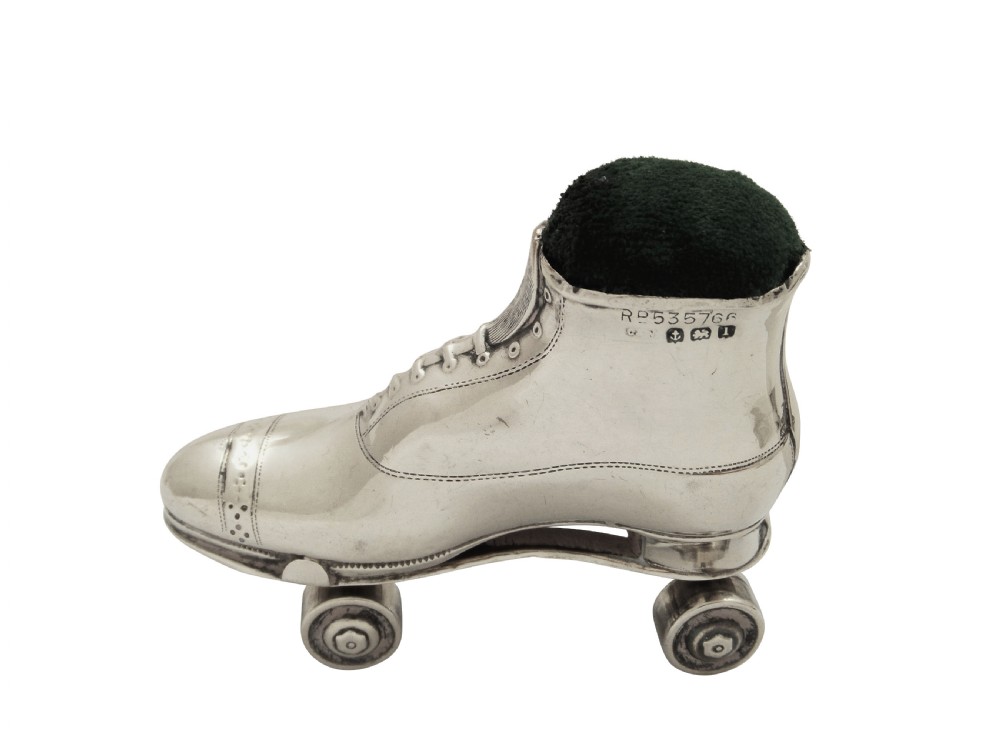 A pair of Edwardian sterling silver roller skate boots fitted with dark green velvet pin cushion tops. View VII