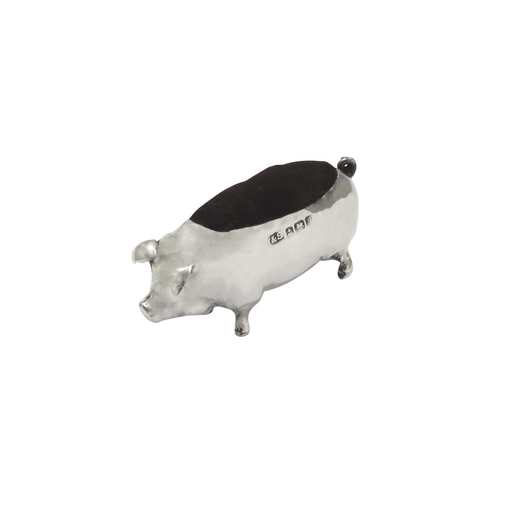 An Edwardian sterling silver novelty pin cushion modelled in the form of a pig with a dark velvet inset cushion along its back.