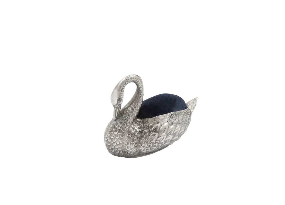 An Edwardian sterling silver pin cushion rendered in the shape of a swan with textured feathers and a dark cushion insert. View II