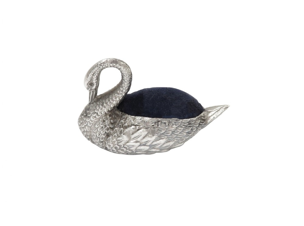 An Edwardian sterling silver pin cushion rendered in the shape of a swan with textured feathers and a dark cushion insert. View VI
