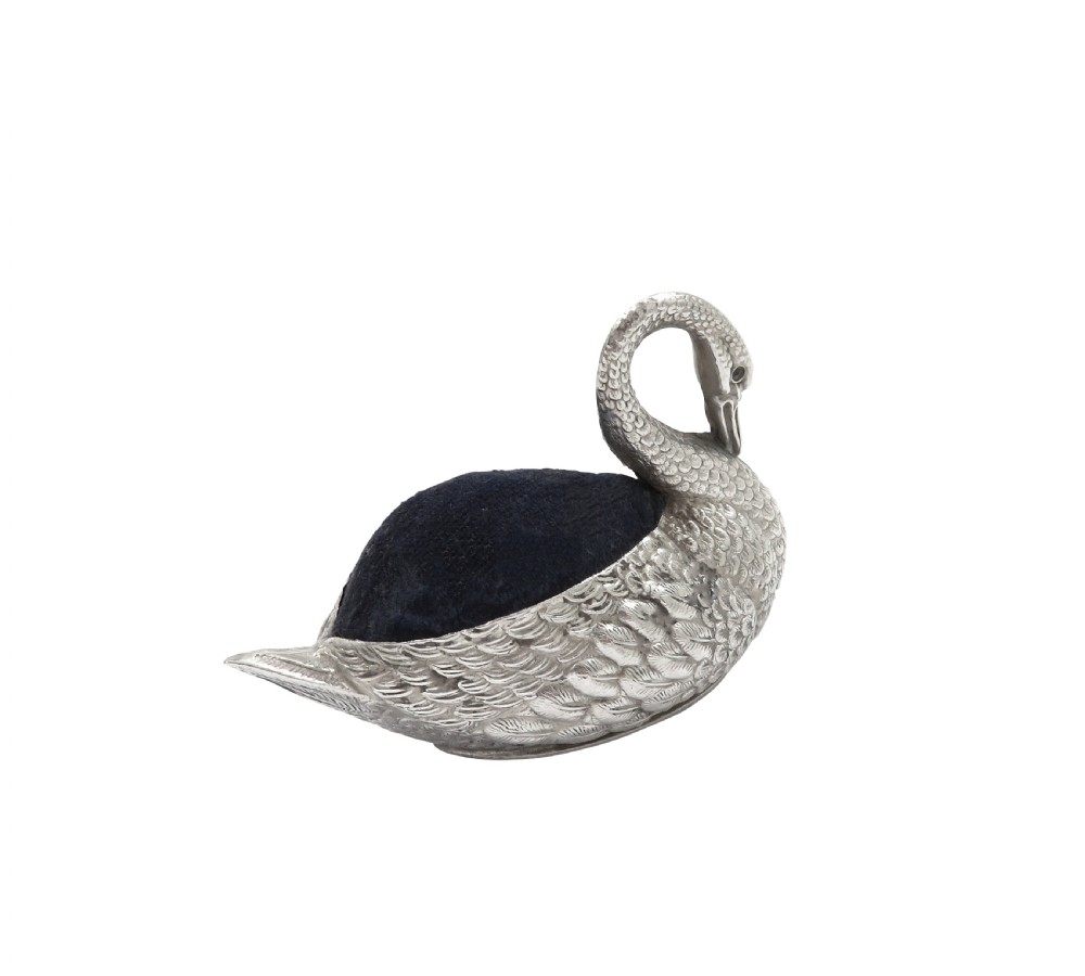 An Edwardian sterling silver pin cushion rendered in the shape of a swan with textured feathers and a dark cushion insert. View VII