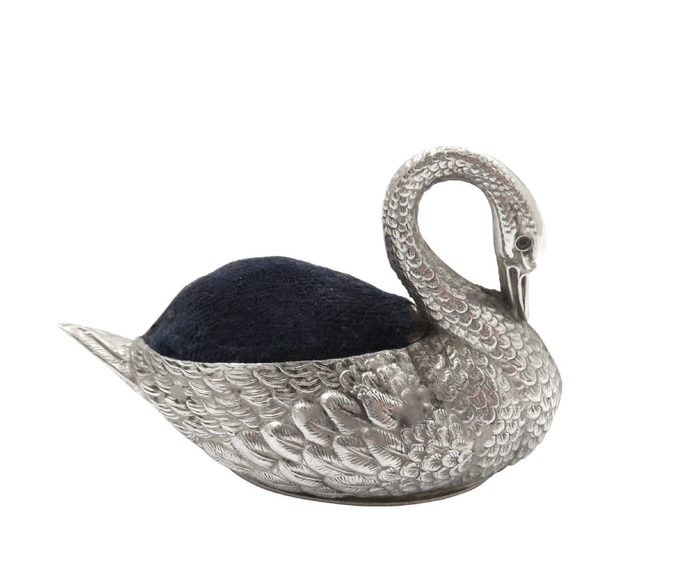 An Edwardian sterling silver pin cushion rendered in the shape of a swan with textured feathers and a dark cushion insert. View VIII