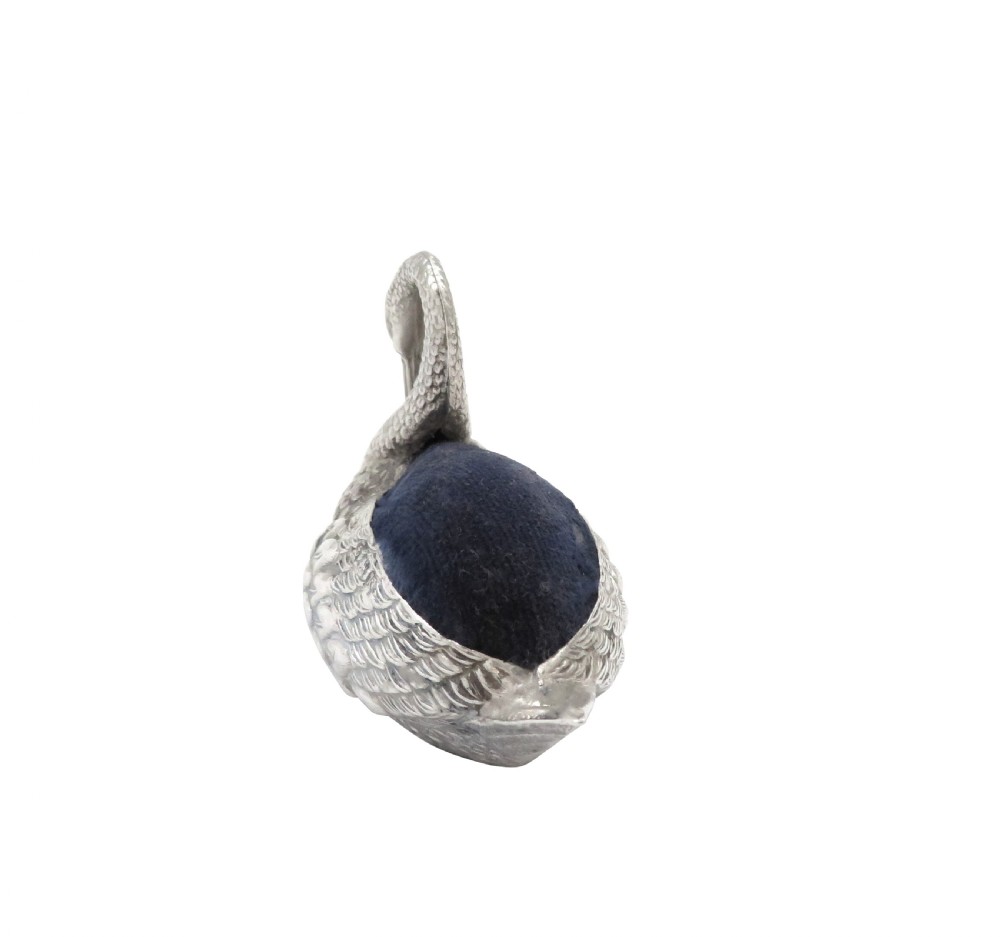 An Edwardian sterling silver pin cushion rendered in the shape of a swan with textured feathers and a dark cushion insert. View XI