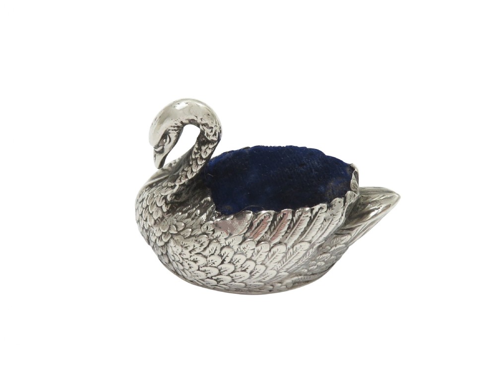An Edwardian sterling silver pin cushion cast in the form of a swan with a blue velvet fabric insert. View II