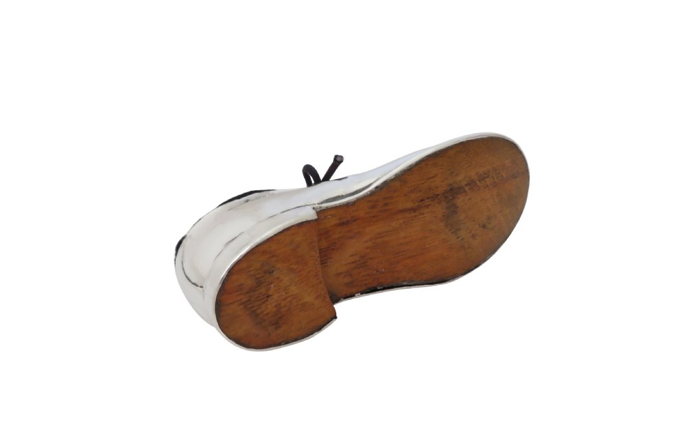 An Edwardian sterling silver pin cushion crafted in the shape of a shoe with a black velvet pad and fabric laces. View VI
