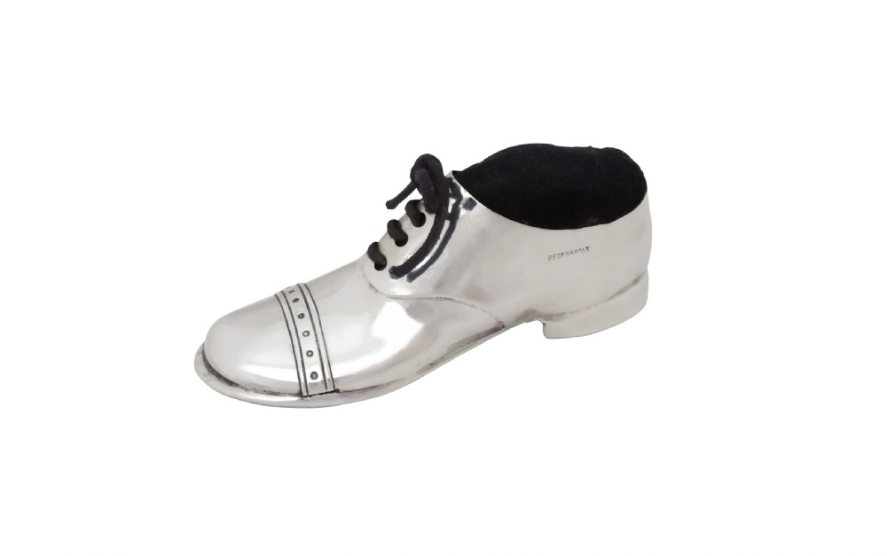 An Edwardian sterling silver pin cushion crafted in the shape of a shoe with a black velvet pad and fabric laces. View VIII