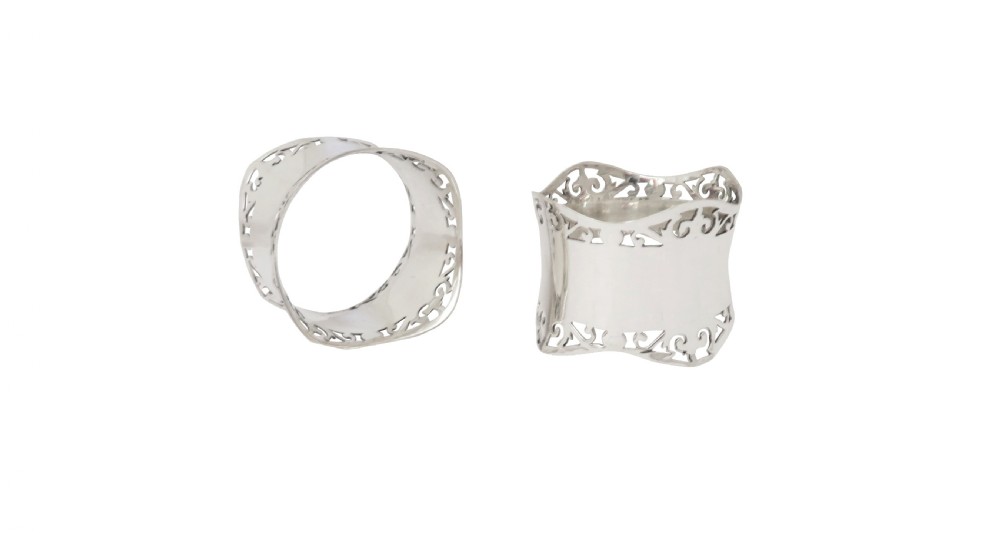 A pair of hallmarked sterling silver napkin rings with pierced borders, presented inside an open black fitted case lined with green satin. View V