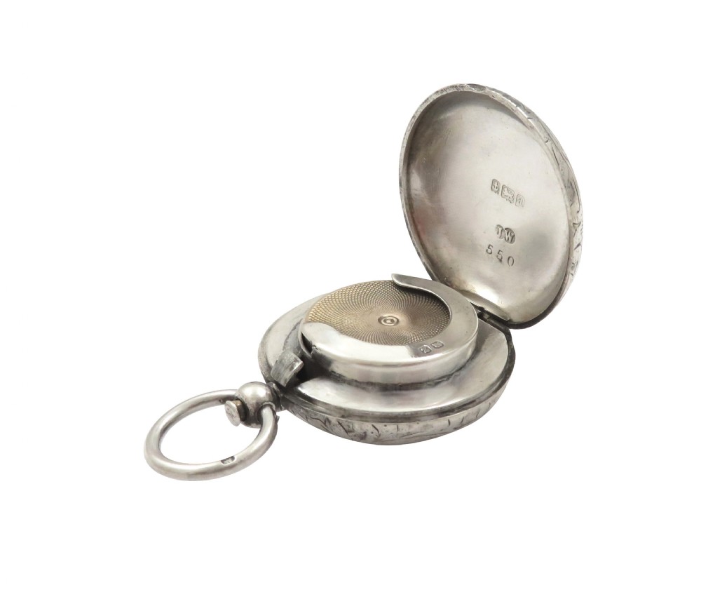 A circular Victorian sterling silver sovereign case with hand-engraved scroll patterns, a blank shield cartouche, and a top suspension ring. View VIII
