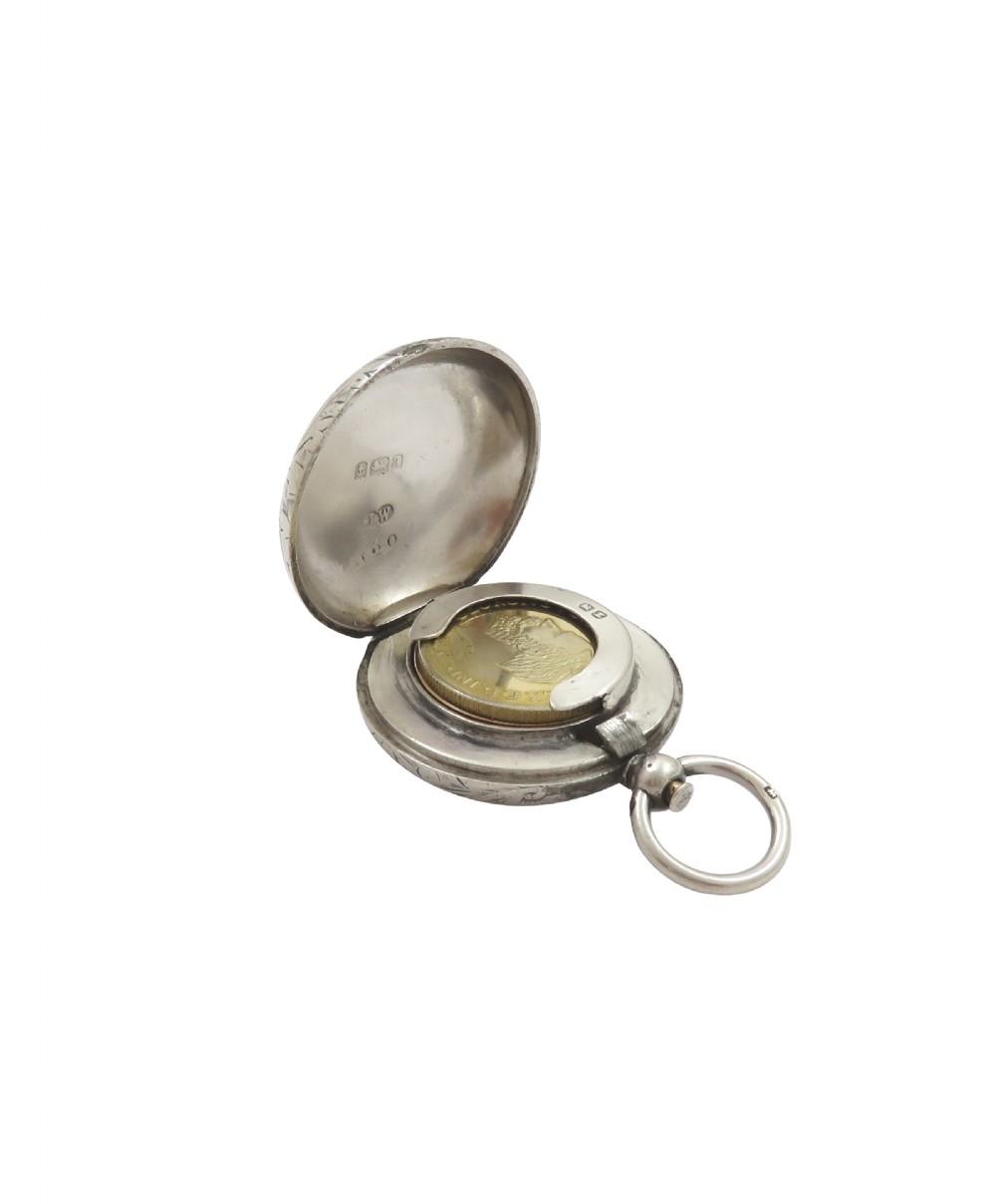 A circular Victorian sterling silver sovereign case with hand-engraved scroll patterns, a blank shield cartouche, and a top suspension ring. View IX