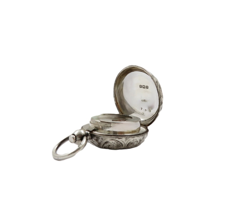 A circular Edwardian sterling silver sovereign case decorated with hand-engraved foliate scrollwork and featuring a top suspension ring. View V