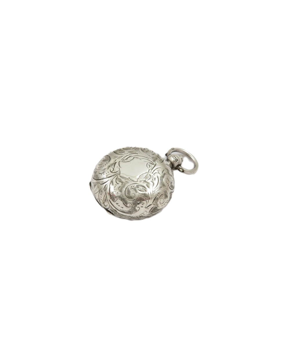 A circular Edwardian sterling silver sovereign case decorated with hand-engraved foliate scrollwork and featuring a top suspension ring. View VII