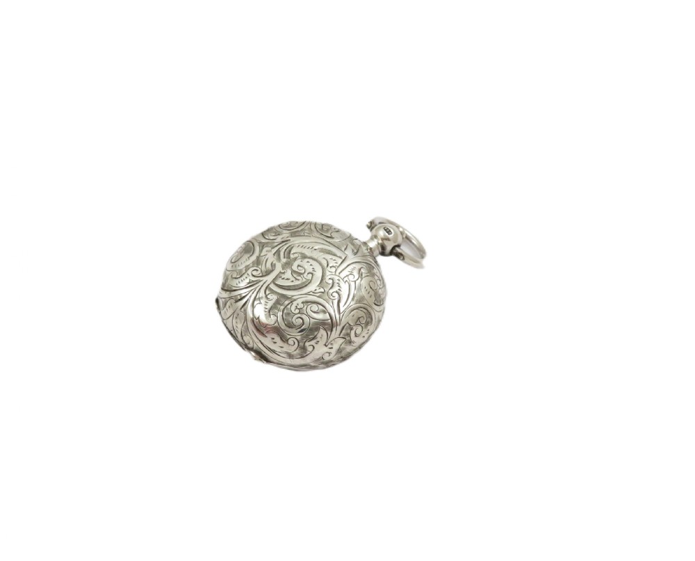 A circular Edwardian sterling silver sovereign case decorated with hand-engraved foliate scrollwork and featuring a top suspension ring. View IX