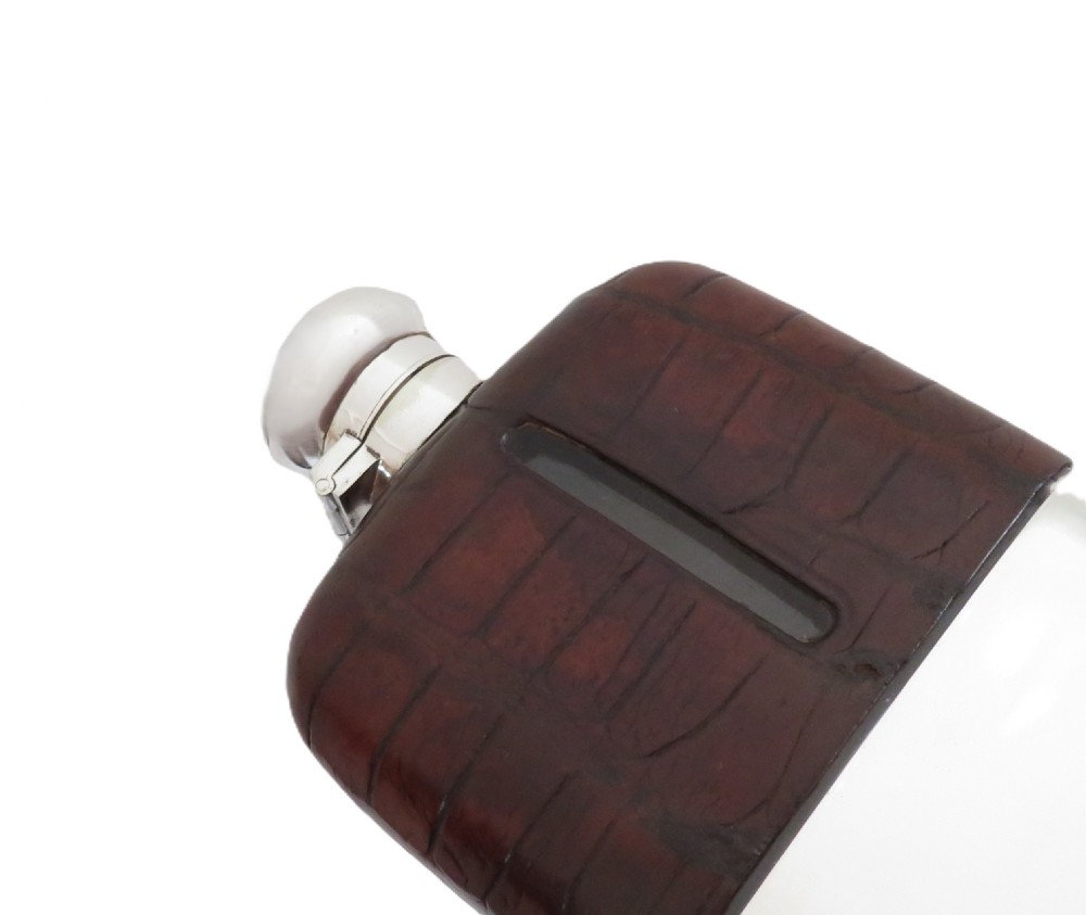 An antique silver-plated and dark brown crocodile leather hip flask featuring a removable base cup and sight level window. View II