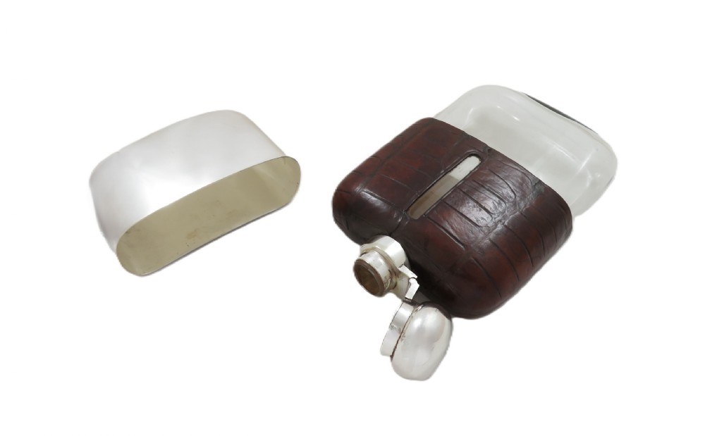 An antique silver-plated and dark brown crocodile leather hip flask featuring a removable base cup and sight level window. View III