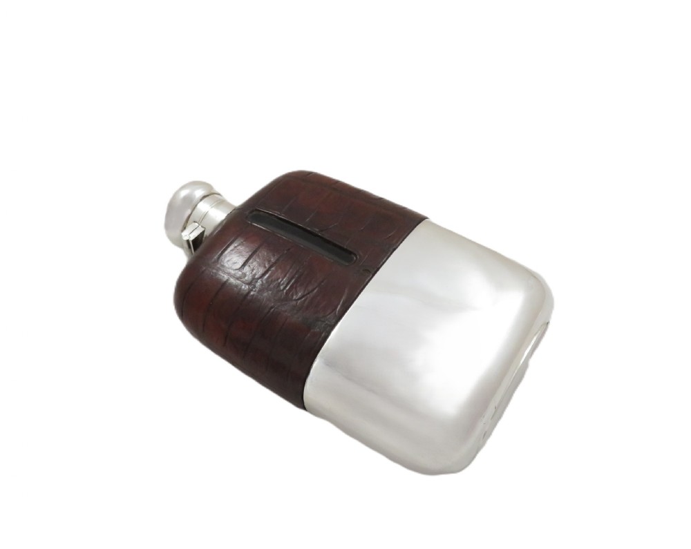 An antique silver-plated and dark brown crocodile leather hip flask featuring a removable base cup and sight level window. View VII