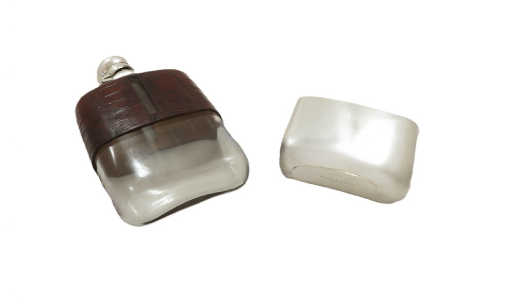 An antique silver-plated and dark brown crocodile leather hip flask featuring a removable base cup and sight level window. View IX