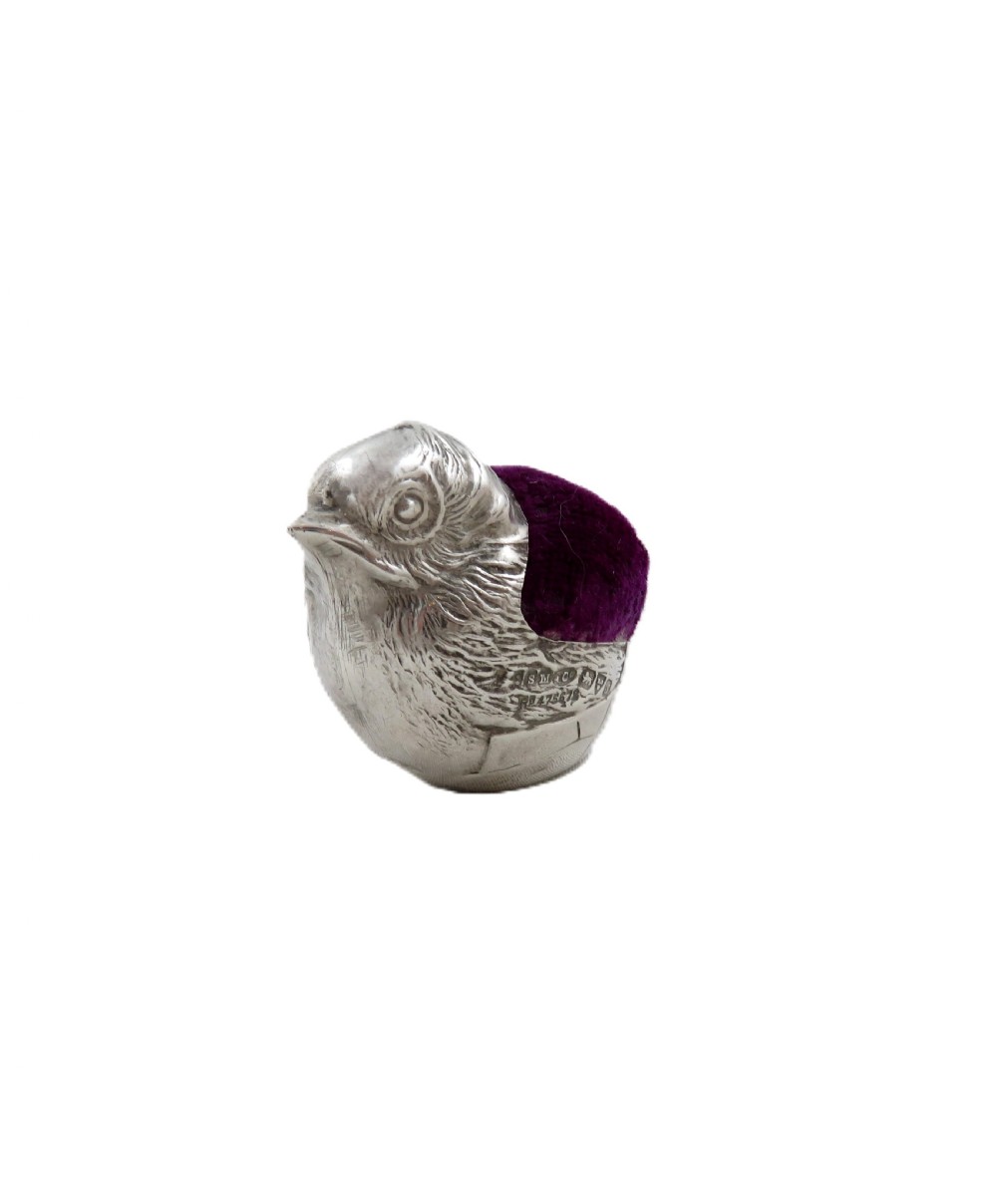 An Edwardian sterling silver pin cushion crafted in the shape of a chick with a purple velvet cushion inset into its back. View V