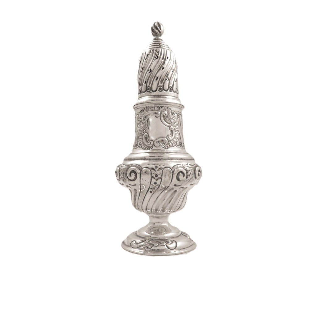 An Edwardian sterling silver sugar castor featuring a spirally fluted pierced dome lid, embossed scroll cartouche, and a turned pedestal foot.