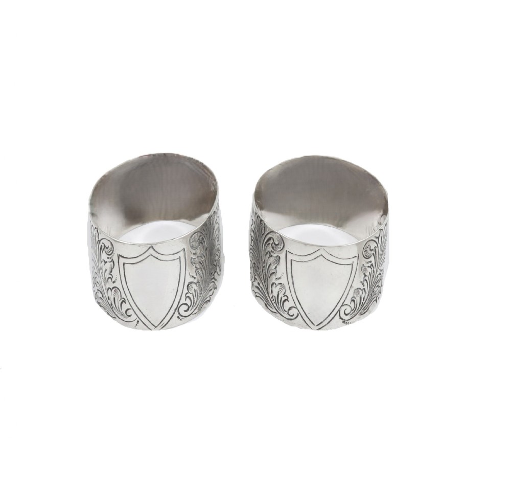 A pair of engraved Victorian sterling silver napkin rings set inside a red silk and velvet lined presentation box. View III
