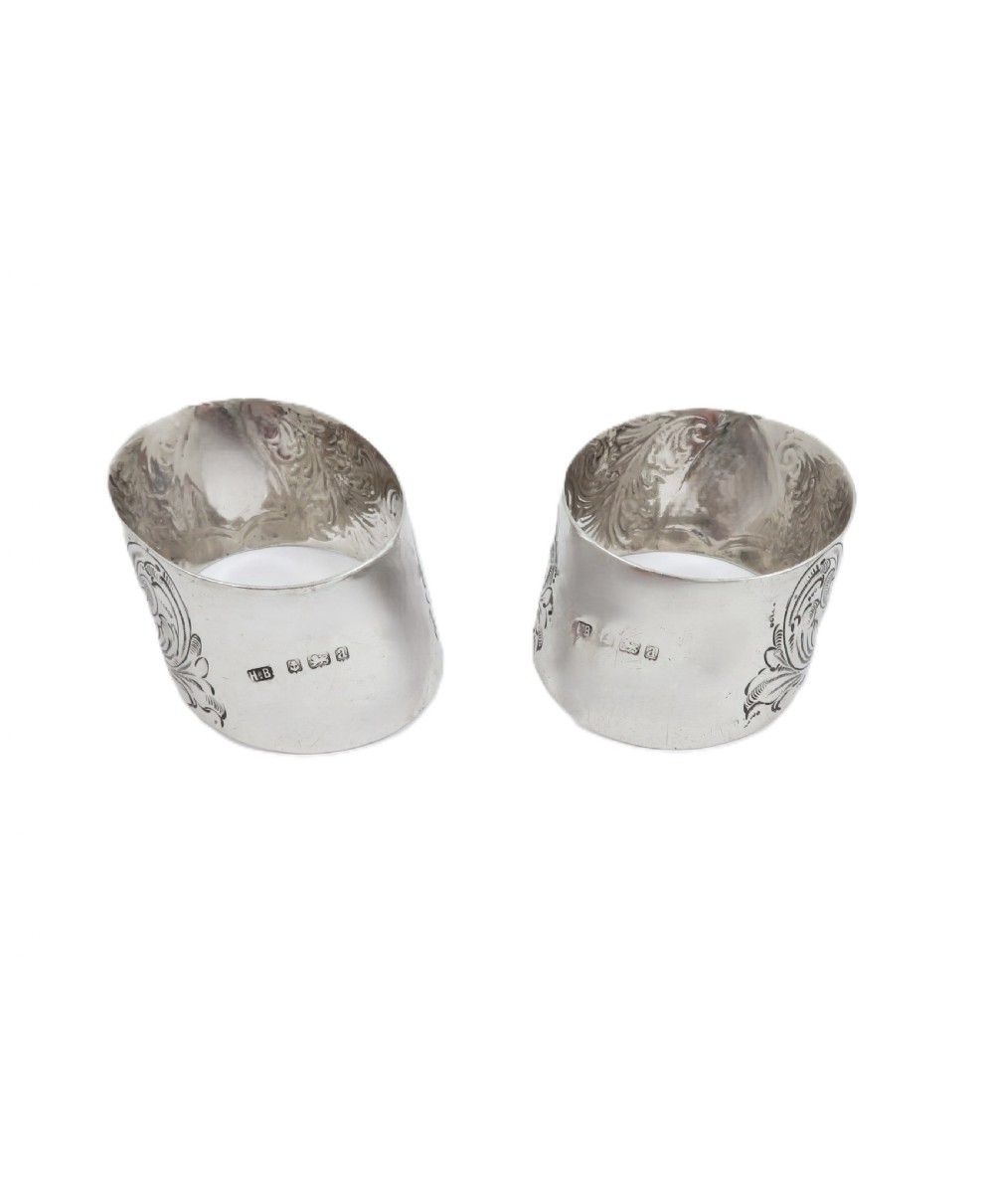 A pair of engraved Victorian sterling silver napkin rings set inside a red silk and velvet lined presentation box. View VIII